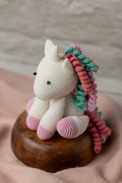 Handmade crochet amigurumi unicorn with soft white body and vibrant rainbow mane made by artisan crafters magical kids gift Australia