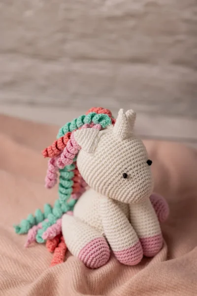 Handmade crochet amigurumi unicorn with soft white body and vibrant rainbow mane made by artisan crafters magical kids gift Australia