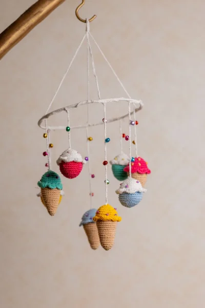 Crochet ice cream cupcake cot hanging showing full mobile with colourful sweet treat characters handmade ethical nursery decor