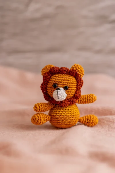 Crochet lion toy and rattle set shown together displaying warm mane detail and coordinated design handmade baby shower gift Melbourne