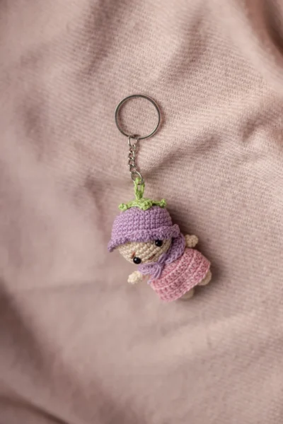 Small amigurumi pink and purple doll keychain showing full doll detail handmade ethical bag charm Australia