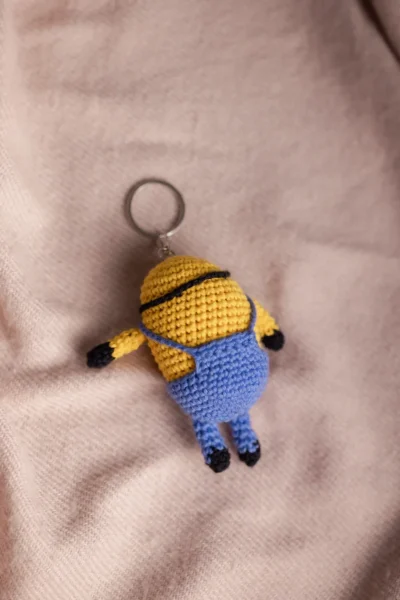Handmade crochet two eyed yellow character keyring with goggles and overalls made by artisan crafters Australia