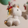 Handmade crochet rainbow unicorn nursery mobile with white unicorn and rainbow mane made by artisan women in India Australia