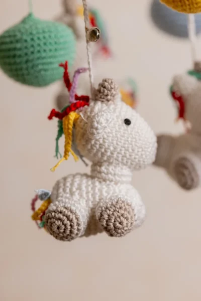 Handmade crochet rainbow unicorn nursery mobile with white unicorn and rainbow mane made by artisan women in India Australia