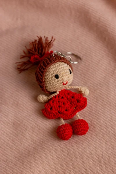 Close up of handmade red dress crochet keyring showing dress detail and stitch work