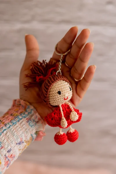 Close up of handmade red dress crochet keyring showing dress detail and stitch work