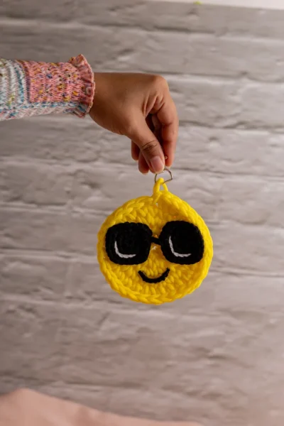 Yellow crochet smiley face keychain showing stitched eyes and smile handmade ethical bag charm Australia