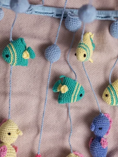 Handmade crochet zoo animal nursery mobile featuring colourful crochet animals made by artisan women in India Australia