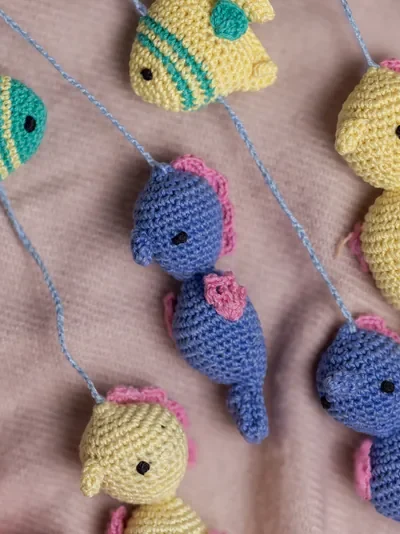 Handmade crochet zoo animal nursery mobile featuring colourful crochet animals made by artisan women in India Australia