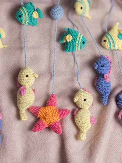 Handmade crochet zoo animal nursery mobile featuring colourful crochet animals made by artisan women in India Australia