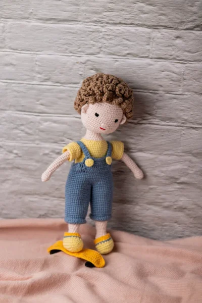 Amigurumi skater boy doll seated with miniature skateboard showing tight secure yarn stitching and detailed sneakers Australia