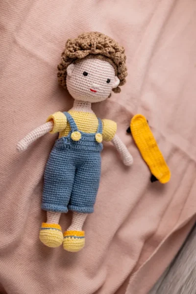 Close up of handmade crochet boy doll face showing hand stitched features and soft yarn texture artisan made soft toy Australia