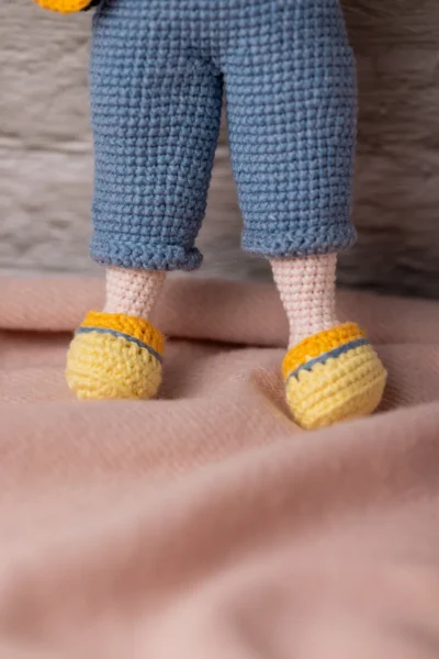 Close up of handmade crochet boy doll face showing hand stitched features and soft yarn texture artisan made soft toy Australia