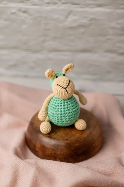 Aster the sheep crochet toy seated upright on nursery shelf showing soft white woolly texture ethical handmade gift Melbourne