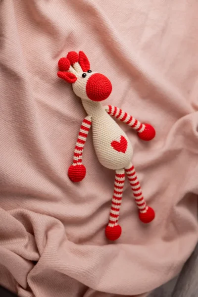 Handmade crochet Azizi giraffe soft toy with warm spot pattern long neck and gentle embroidered face made by artisan crafters Australia