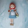 Bella the doll full body view showing soft crochet cotton yarn dress and hand stitched features ethical handmade toy Melbourne