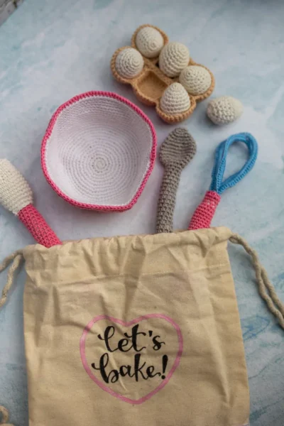 Full 6 piece crochet baking set laid out showing all pieces baker doll bowl eggs and whisk handmade kids gift Melbourne