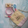 Full 6 piece crochet baking set laid out showing all pieces baker doll bowl eggs and whisk handmade kids gift Melbourne