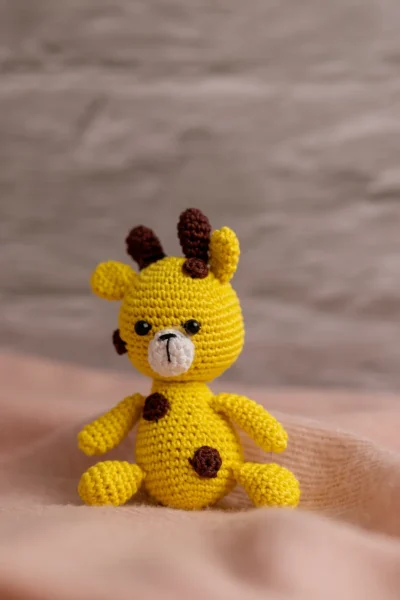 Crochet giraffe rattle and toy set styled in nursery context ethical handmade baby gift Melbourne Australia