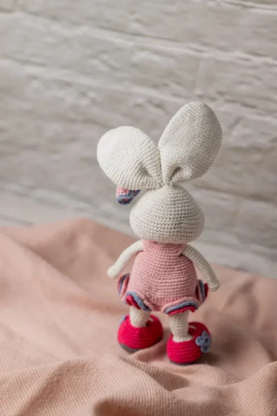 Full body view of crochet bunny rabbit doll in pink crocheted dress showing long ears soft yarn body and bow detail Melbourne