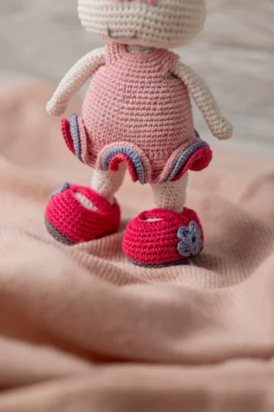 Full body view of crochet bunny rabbit doll in pink crocheted dress showing long ears soft yarn body and bow detail Melbourne