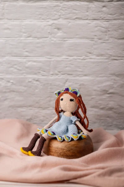 Full body view of crochet doll with red hair blue dress and boots showing soft yarn body and stitched face Melbourne Australia