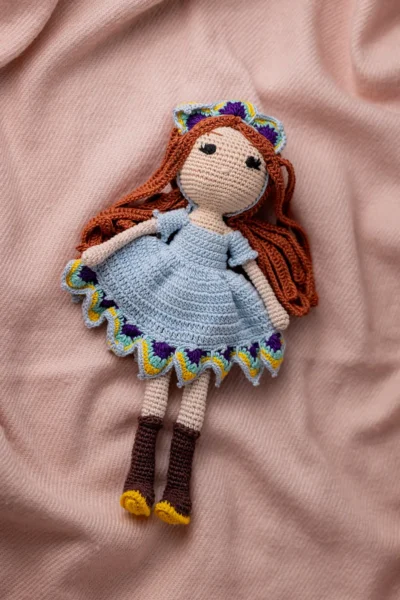 Handmade crochet amigurumi doll with vibrant red yarn hair blue crocheted dress and brown boots made by artisan crafters gift Australia