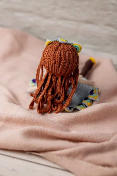 Close up of handmade amigurumi doll with red yarn hair showing embroidered face and blue dress detail artisan made gift Australia