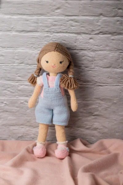 Full body view of crochet Ruby doll in classic blue dungarees showing soft amigurumi proportions and yarn texture Melbourne