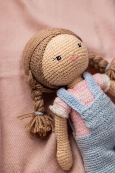 Full body view of crochet Ruby doll in classic blue dungarees showing soft amigurumi proportions and yarn texture Melbourne