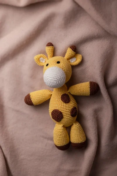 Close up of handmade crochet Boban giraffe face showing hand stitched features soft yarn texture artisan made baby gift Australia