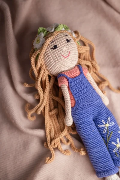 Front view of handmade crochet boho daisy doll with stitched face and soft cotton yarn details artisan made gift Australia